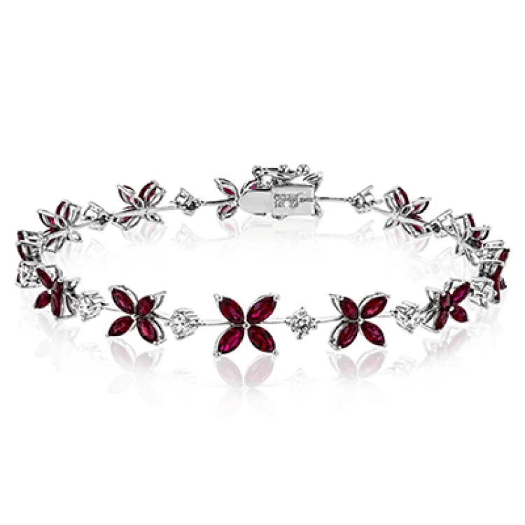 Women’s gold and diamond bracelets-This bracelet charms with a floral design set with 3.58 ctw of rubies and .96 ctw of white diamonds.